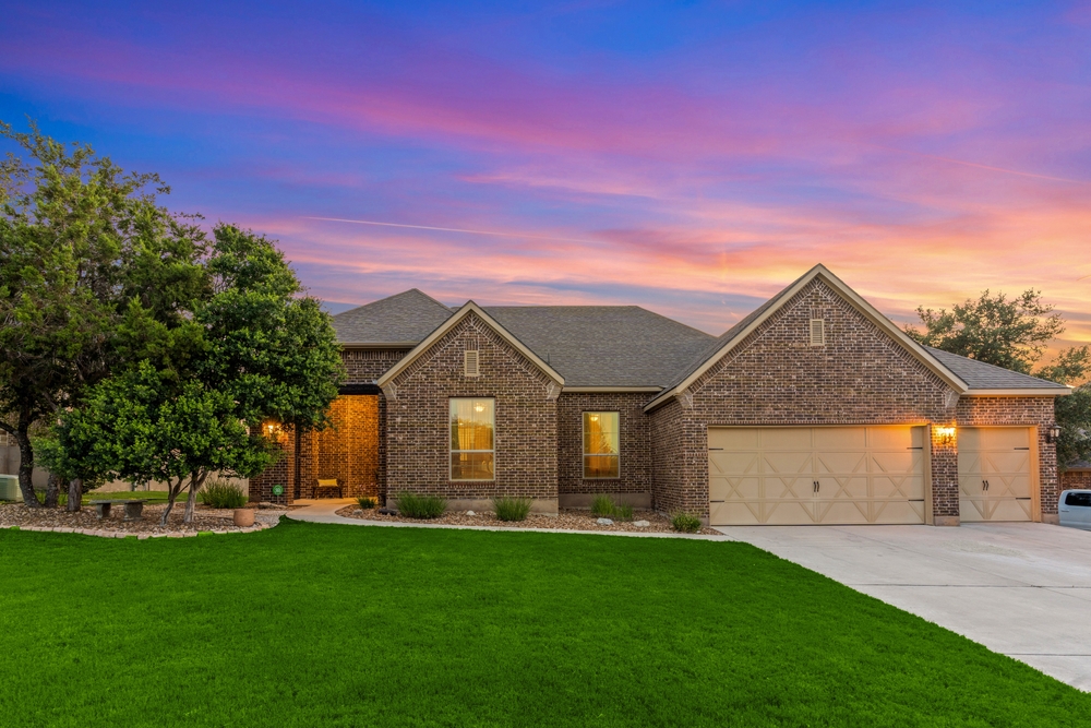 home in texas at sunset with windows illuminated